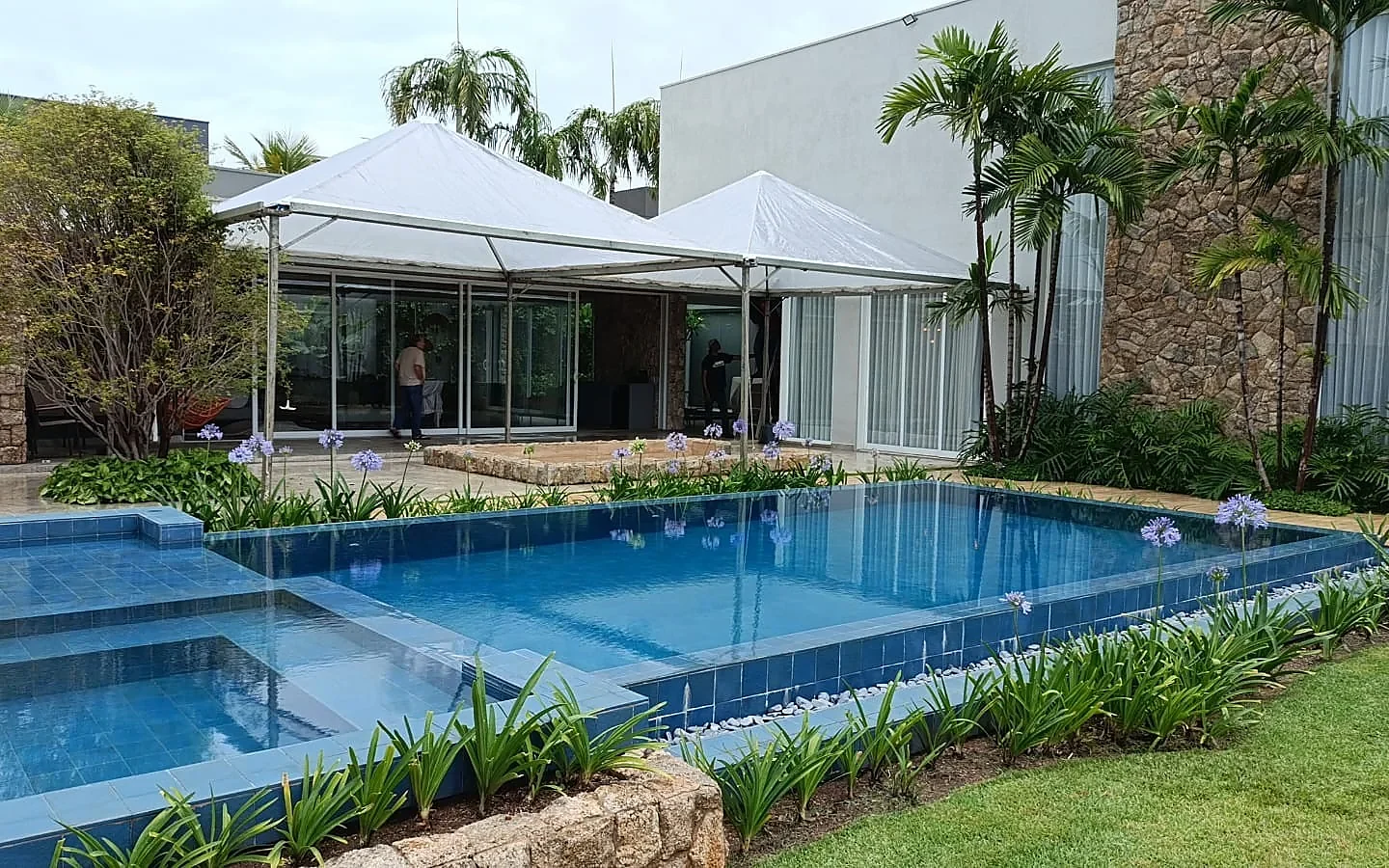 Tendas piramidais ao lado da piscina de uma casa